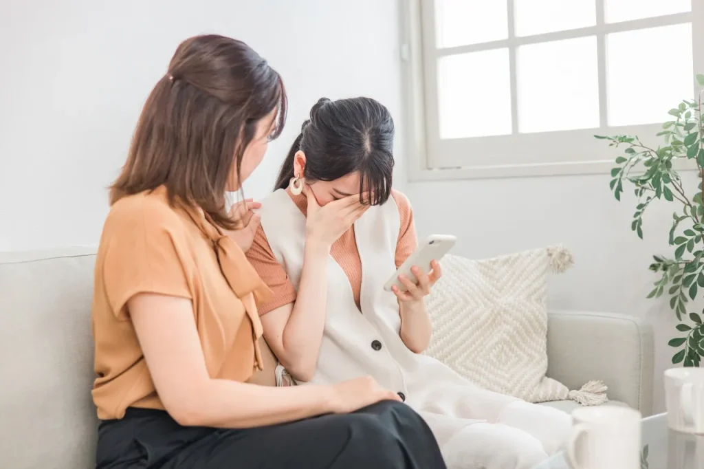 落ち込む友人を励ます女性