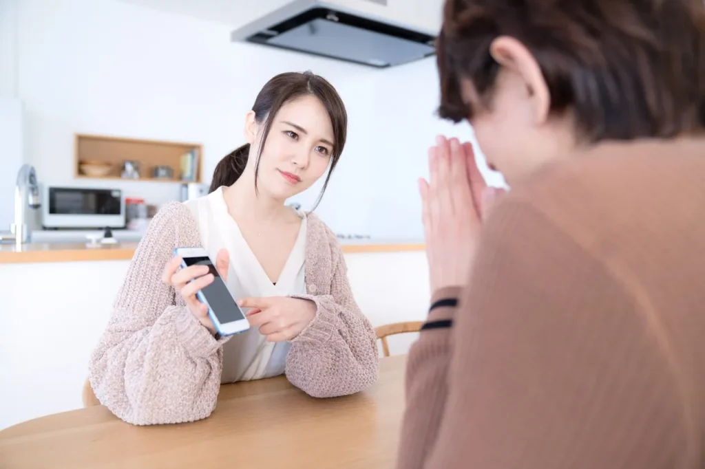 問い詰める女性と謝る男性